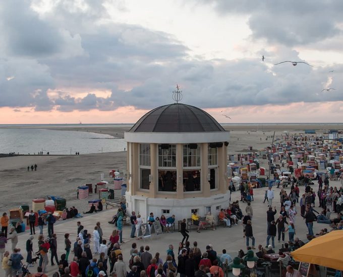 Das Musikpavillon an der Promenade auf Borkum mit vielen Menschen drum herum