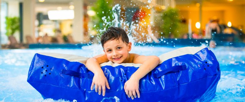 Kind schwimmt auf Matte